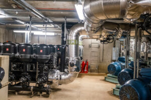 A factory room with pipes and barrels